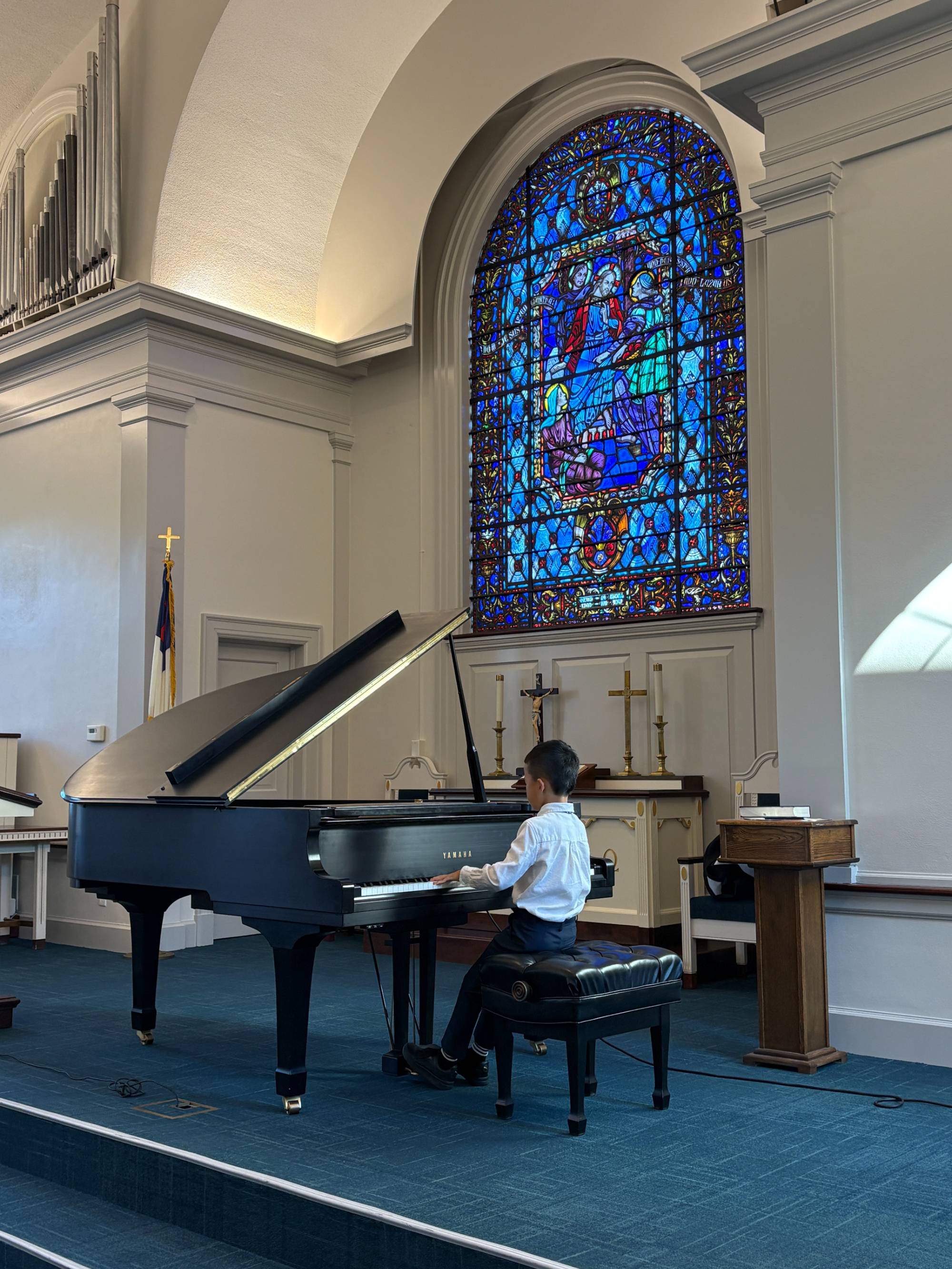 Child playing the piano at the front of a church